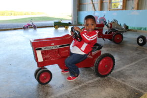 Child riding red tractor